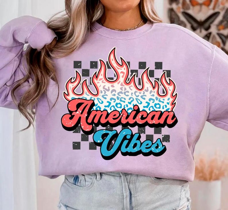 May include: A lavender sweatshirt with a graphic design of flames with a leopard print pattern. The text "American Vibes" is in a retro font.