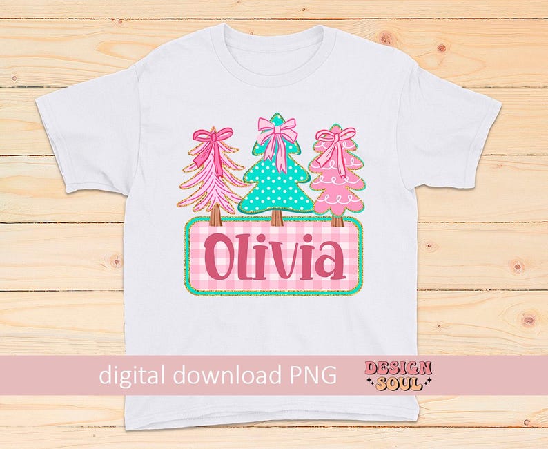 May include: White t-shirt featuring a design with three Christmas trees in pink and teal, each adorned with a bow. The name "Olivia" is displayed on a pink and white checkered background. The words "digital download PNG" are also visible.