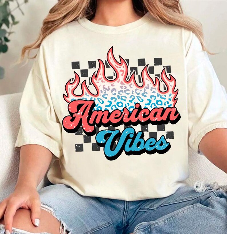 May include: A white t-shirt with a graphic of a flame with a leopard print design. The text "American Vibes" is written in a retro font below the flame.