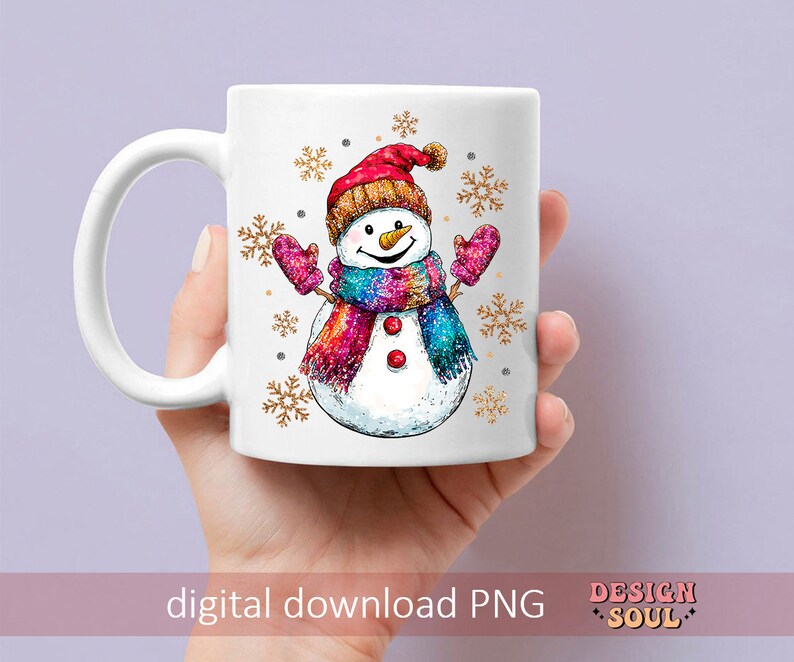 May include: White ceramic mug with a colorful snowman illustration. The snowman is wearing a red hat, a rainbow scarf, and mittens. The background is decorated with gold snowflakes.