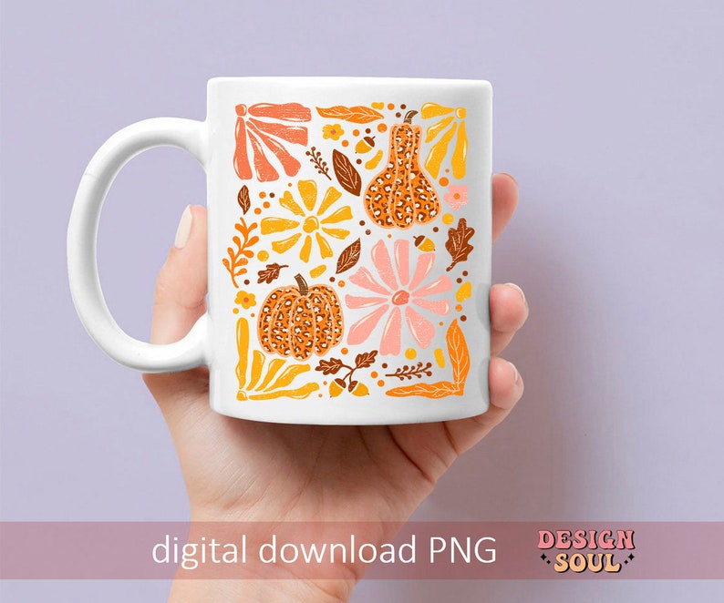May include: A white ceramic mug with a fall-themed design. The design features orange, yellow, and pink flowers, leaves, and pumpkins with a leopard print pattern. The text "DESIGN SOUL" is printed on the bottom of the mug.