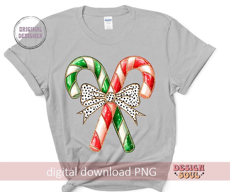 May include: A gray t-shirt with a design of two candy canes tied together with a black and white polka dot bow. The candy canes are red and white with green stripes.