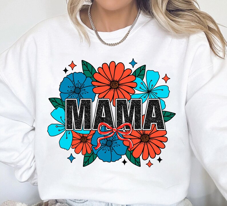 Pu&ograve; includere: Felpa bianca con un design floreale e la parola "MAMA" in lettere nere. I fiori sono rossi, blu e verdi.
