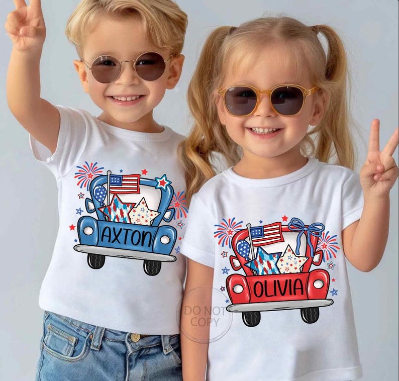 May include: Two children wearing white t-shirts with patriotic designs. The shirts feature a red or blue truck graphic with an American flag, stars, and the names "AXTON" and "OLIVIA". Both children are wearing sunglasses and making peace signs.