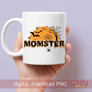 May include: White ceramic mug with a black and orange Halloween design. The design features a crescent moon, bats, a spider web, and the text "Momster".