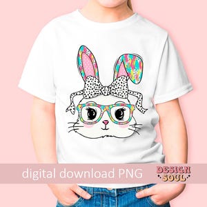 May include: A white t-shirt with a colorful bunny wearing glasses and a bow. The bunny has a pink nose and black eyes. The bunny's ears are patterned with colorful shapes. The t-shirt has the text "digital download PNG" and "DESIGN SOUL" on it.