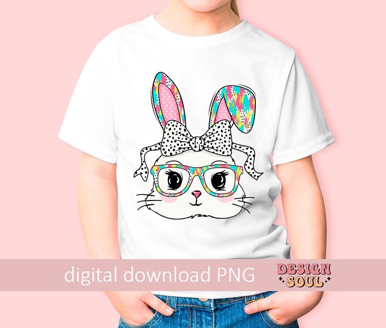May include: A white t-shirt with a colorful bunny wearing glasses and a bow. The bunny has a pink nose and black eyes. The bunny's ears are patterned with colorful shapes. The t-shirt has the text "digital download PNG" and "DESIGN SOUL" on it.