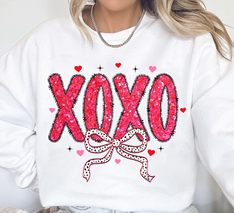 May include: White sweatshirt with a pink glitter XOXO design and a black and white polka dot bow.