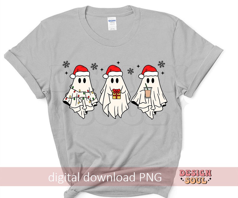 May include: A gray t-shirt with a design of three ghosts wearing Santa hats. The ghosts are holding a gift, a cup of coffee, and Christmas lights.