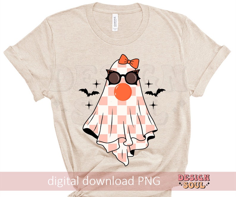 May include: A beige t-shirt with a pink and white checkered ghost wearing sunglasses and a pink bow. The ghost has a red nose and is surrounded by stars and bats.