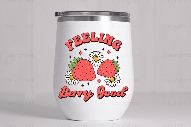 May include: White stainless steel tumbler with a red and green graphic of strawberries and flowers. The text "Feeling Berry Good" is printed in red on the tumbler.