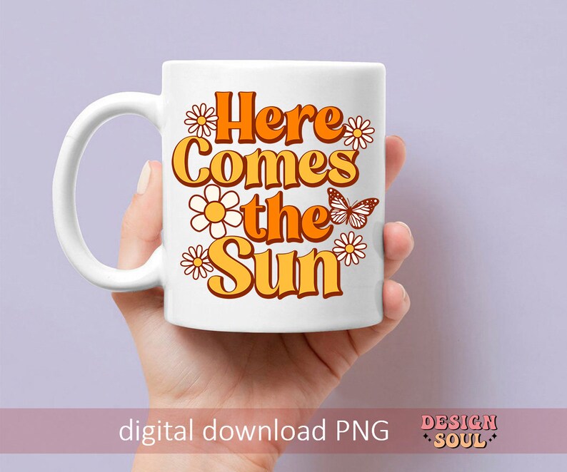 May include: White ceramic mug with a graphic design featuring orange and yellow flowers, a butterfly, and the text "Here Comes the Sun".