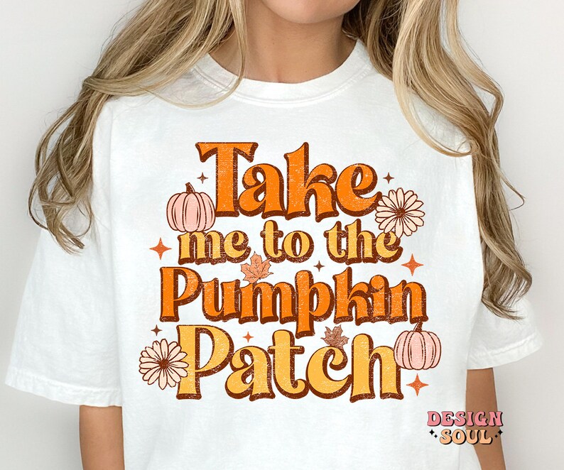 May include: White t-shirt with a vintage-style graphic that says "Take me to the Pumpkin Patch". The graphic features pumpkins, leaves, and flowers in orange, yellow, and brown.