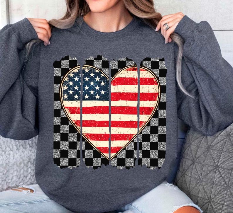 May include: A dark gray sweatshirt with a distressed American flag heart design. The heart is surrounded by a checkered pattern.