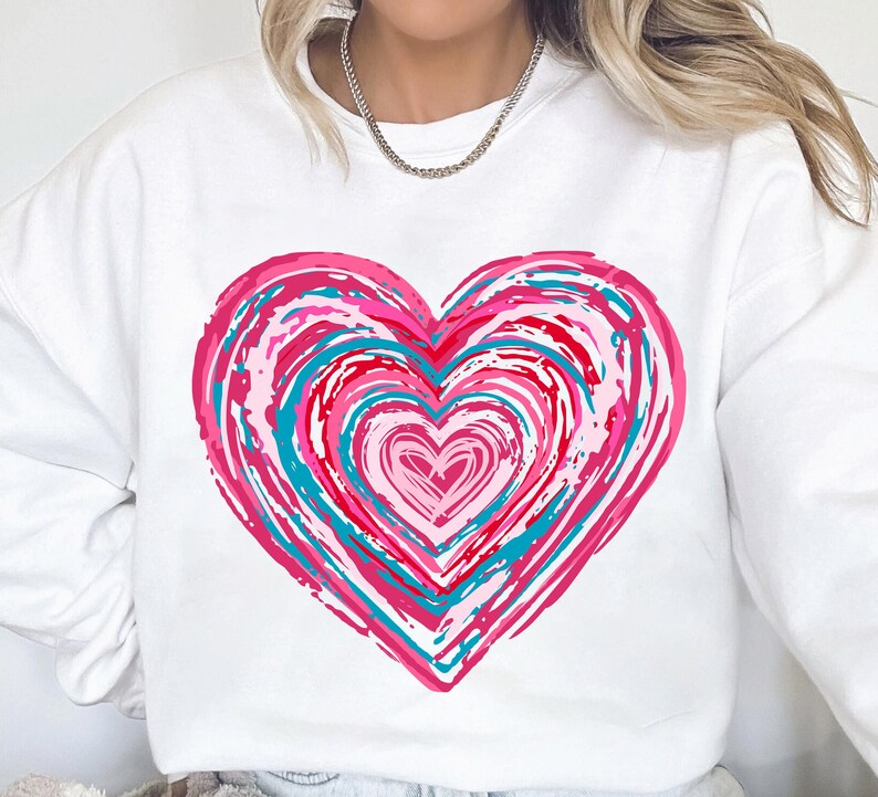 Pu&ograve; includere: Felpa bianca con un design a forma di cuore astratto in rosa, rosso e blu.