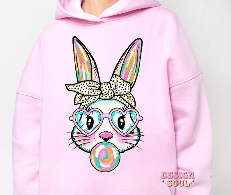 May include: Pink hoodie featuring a cartoon bunny wearing heart-shaped sunglasses and a headband, blowing a bubblegum bubble.