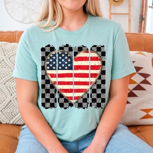 May include: A light blue t-shirt with a distressed checkered pattern and a heart-shaped American flag design.