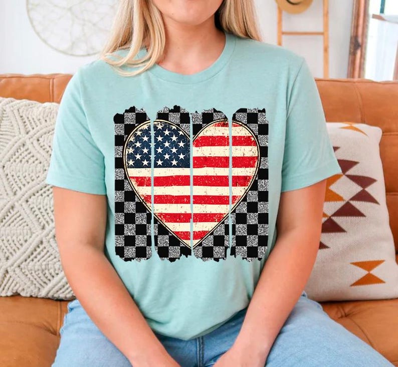 May include: A light blue t-shirt with a distressed checkered pattern and a heart-shaped American flag design.