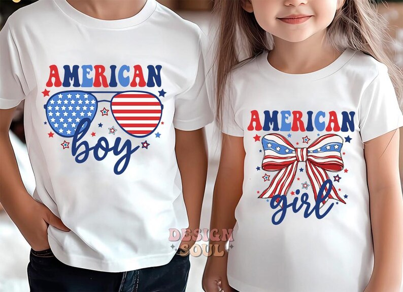 May include: Two white t-shirts with red, white, and blue American flag designs. The boy's shirt says "American Boy" with sunglasses featuring the American flag. The girl's shirt says "American Girl" with a red, white, and blue bow.