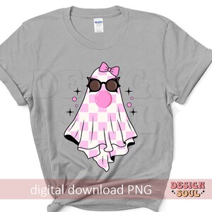 May include: A gray t-shirt with a pink and white checkered ghost wearing sunglasses and a pink bow. The ghost has a pink bubble coming out of its mouth. The text "digital download PNG" is at the bottom of the shirt.