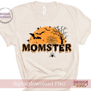 May include: A beige t-shirt with a black and orange graphic design. The design features a spooky Halloween theme with bats, a spider web, a spider, and a moon. The text "MOMSTER" is written in dripping orange letters.