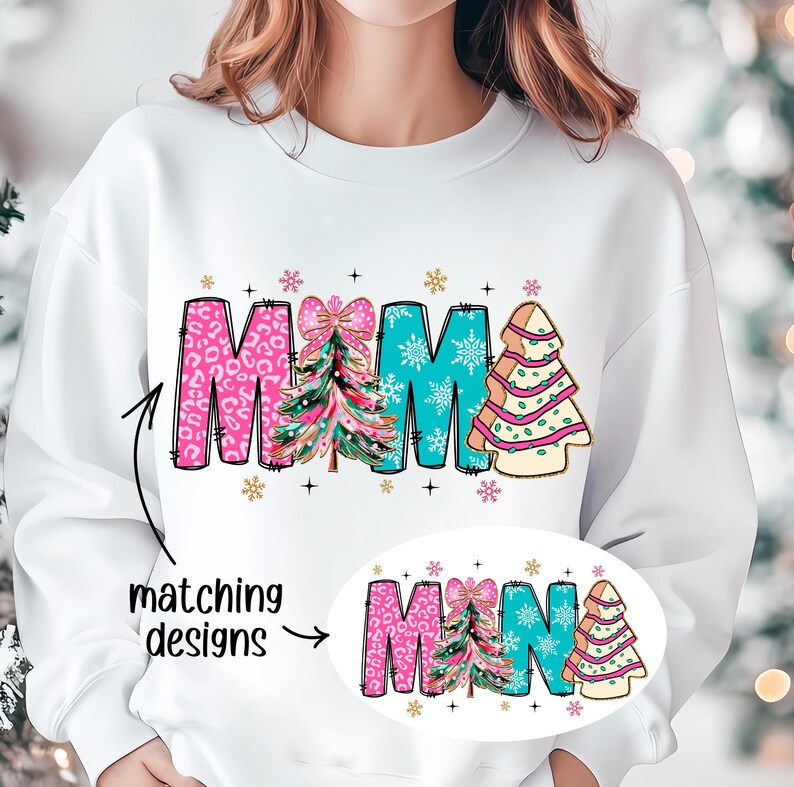 May include: White sweatshirt with the word "MAMA" in pink, blue, and green with a Christmas tree design. The word "MINA" is shown in a smaller size in the bottom right corner of the image.