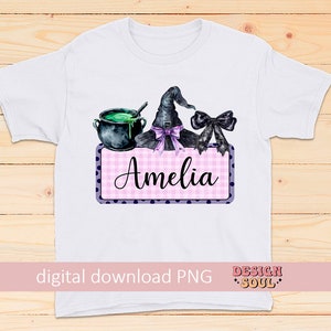 May include: A white t-shirt with a pink and purple gingham and polka dot design featuring a witch's hat, cauldron, and a bow. The text "Amelia" is on the design.