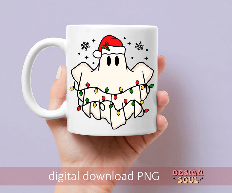 May include: White ceramic mug with a ghost wearing a Santa hat and surrounded by Christmas lights. The mug has a black handle and a white background.