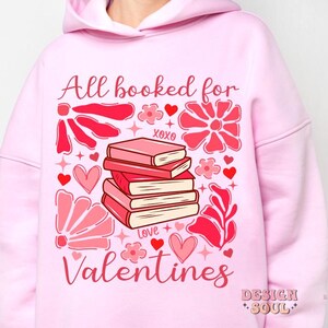 May include: Pink hoodie with a graphic design of a stack of books, hearts, flowers, and the text "All booked for Valentines".