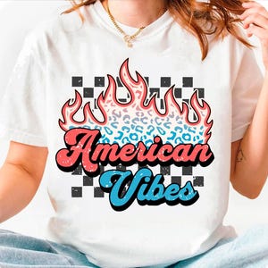 May include: White t-shirt with a graphic of a flame with a leopard print design. The text "American Vibes" is in a retro font.