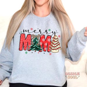 May include: A gray sweatshirt with the text "merry MAMA" in red and white letters with a green and white Christmas tree design.