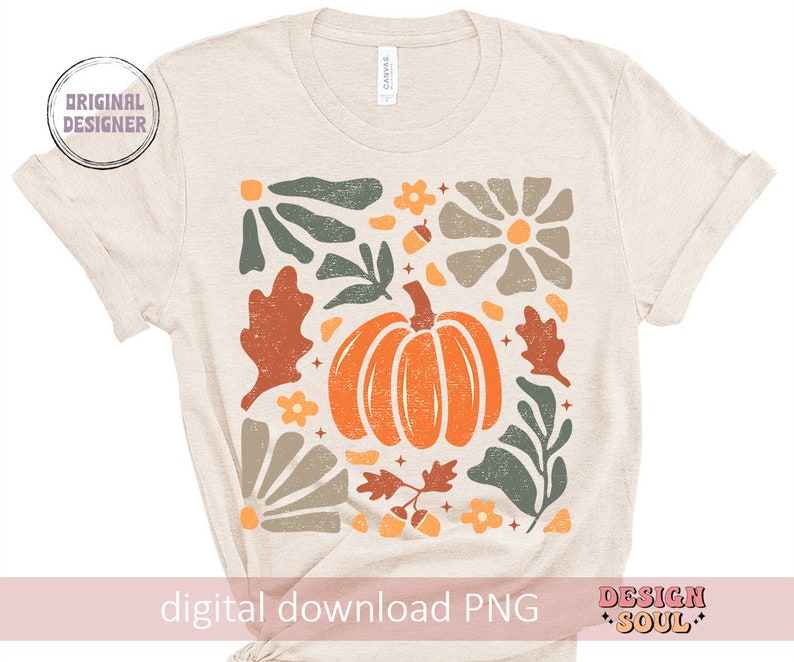 May include: A beige t-shirt featuring a digital print of a pumpkin and autumn foliage in shades of orange, green, brown, and grey. The design includes a stylised pumpkin, leaves, and flowers. The text "digital download PNG" is at the bottom of the shirt.