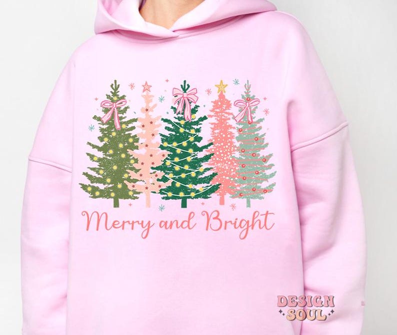 May include: Pink hoodie with a graphic of four Christmas trees with pink bows and the text "Merry and Bright".