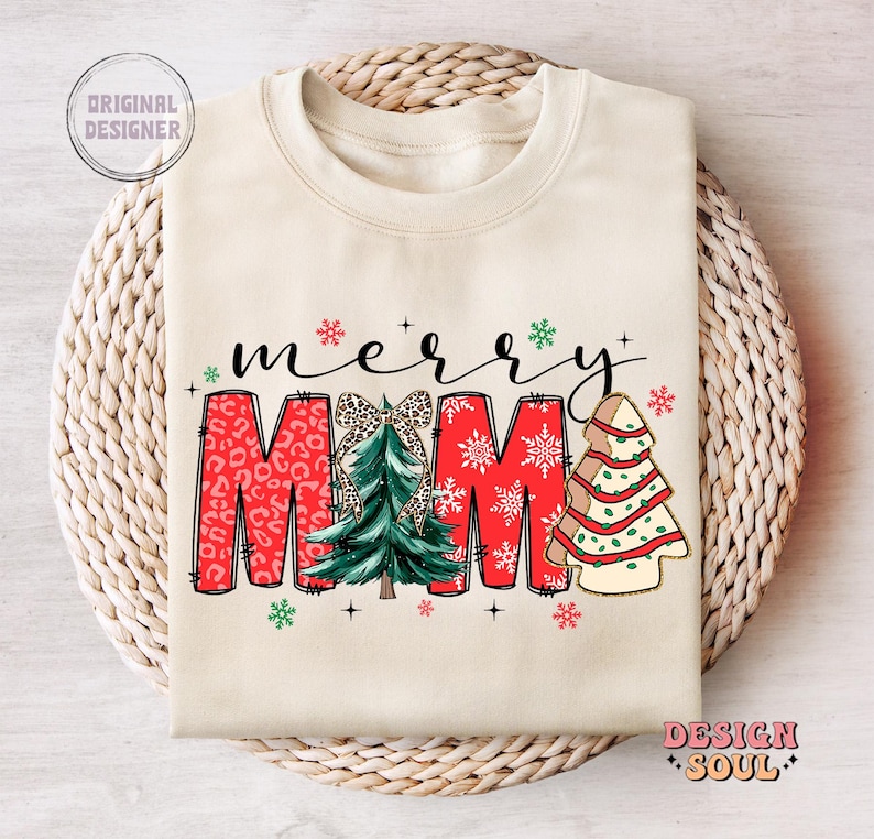 May include: A cream-colored sweatshirt with the text "merry mama" in red, green, and white. The text is decorated with a Christmas tree, snowflakes, and leopard print.