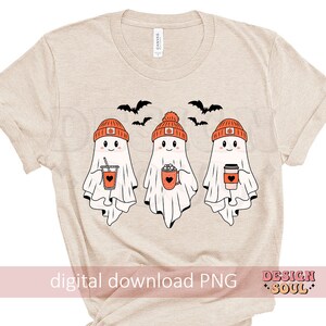 May include: Beige t-shirt featuring three cartoon ghosts wearing orange beanies with pumpkin designs. Each ghost holds a beverage, including coffee and a pumpkin spice drink. Black bats fly above the ghosts. The text "digital download PNG" is at the bottom.