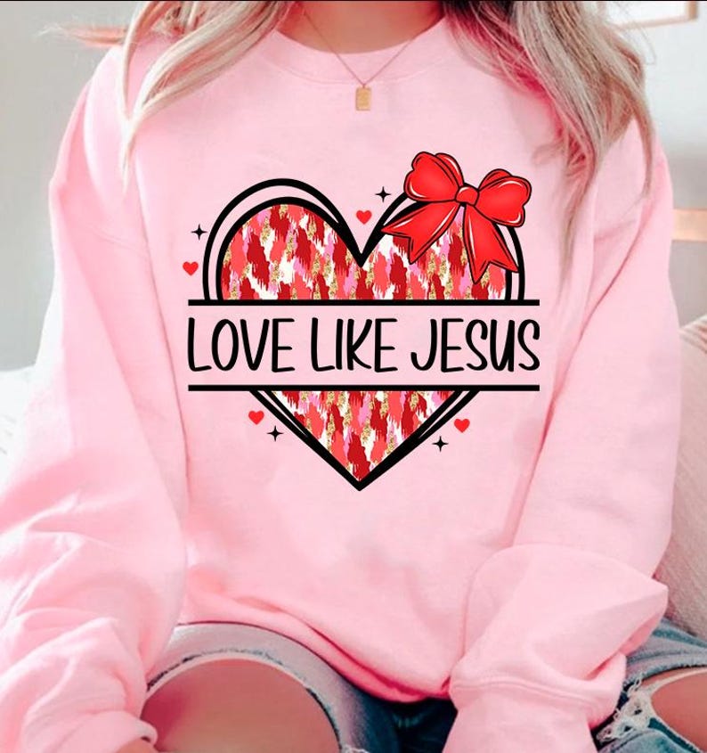 May include: Pink sweatshirt with a red and gold heart design and the text "LOVE LIKE JESUS".