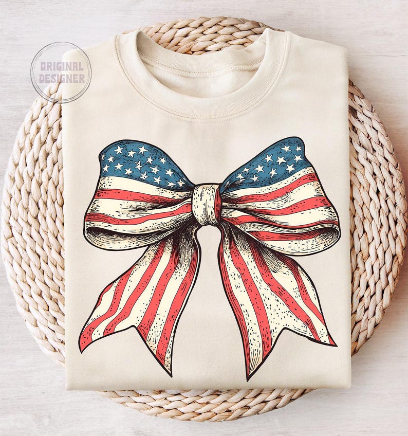 Peut inclure: Un sweat-shirt beige avec un grand n&oelig;ud rouge, blanc et bleu imprim&eacute; sur le devant. Le n&oelig;ud est con&ccedil;u pour ressembler &agrave; un drapeau am&eacute;ricain.