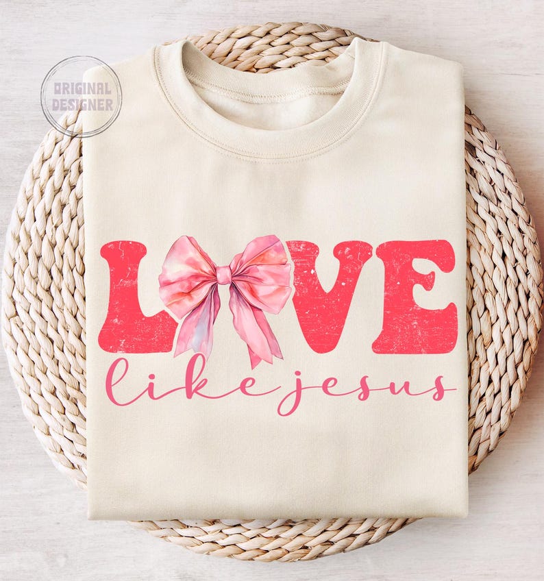May include: A cream-coloured sweatshirt with the words "LOVE like jesus" in pink lettering. A pink bow is centred above the text.