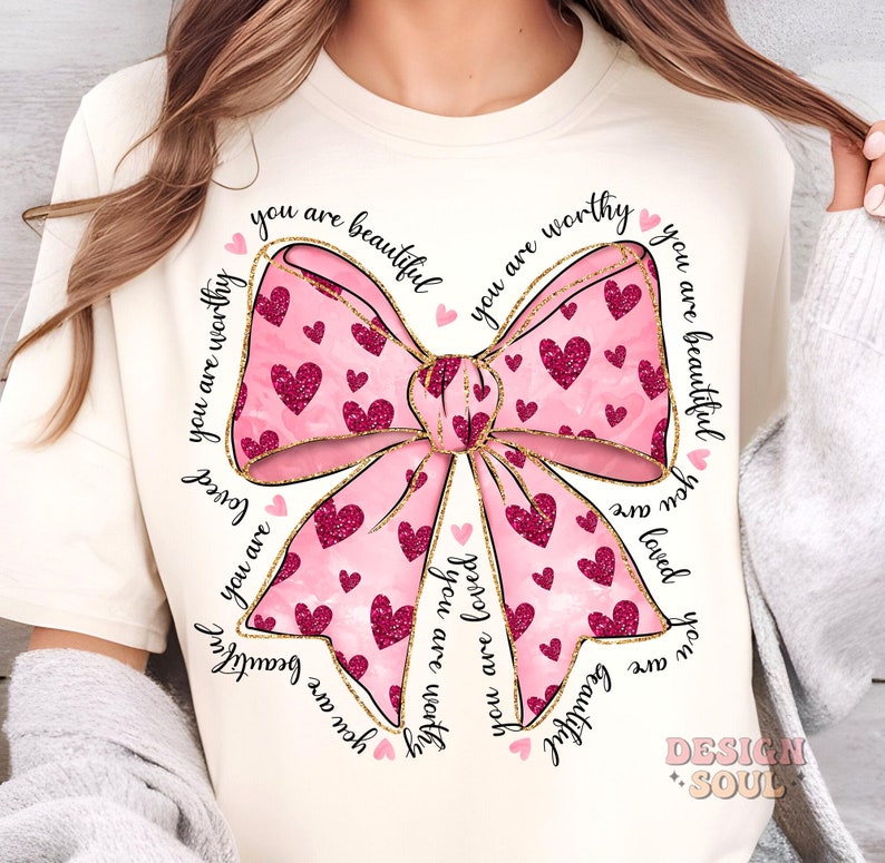 May include: A pink and gold bow with a glitter design and the words "you are beautiful you are worthy you are loved you are beautiful you are worthy" surrounding it.