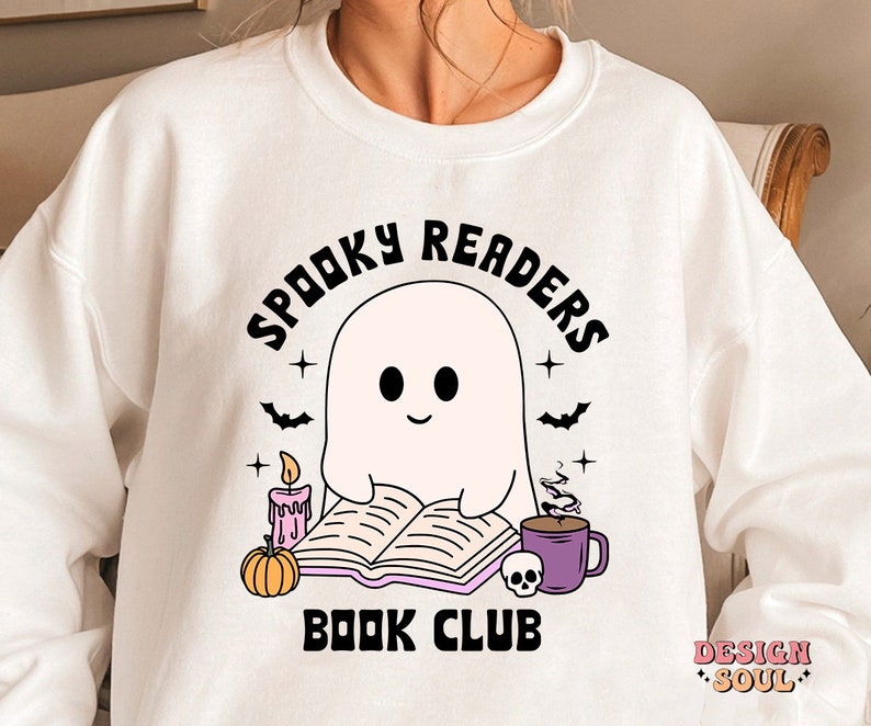 May include: White sweatshirt with a black and white illustration of a ghost reading a book. The text "Spooky Readers Book Club" is printed on the sweatshirt.