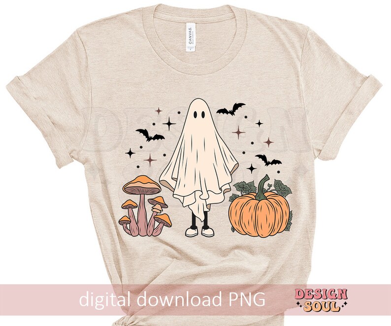 May include: A beige t-shirt with a ghost, mushrooms, and a pumpkin design. The ghost is white and has a friendly face. The mushrooms are orange and brown. The pumpkin is orange and has a green stem. The design is in a vintage style.