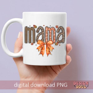 May include: White ceramic mug with a brown, black, and orange design that says "mama" with a bow.