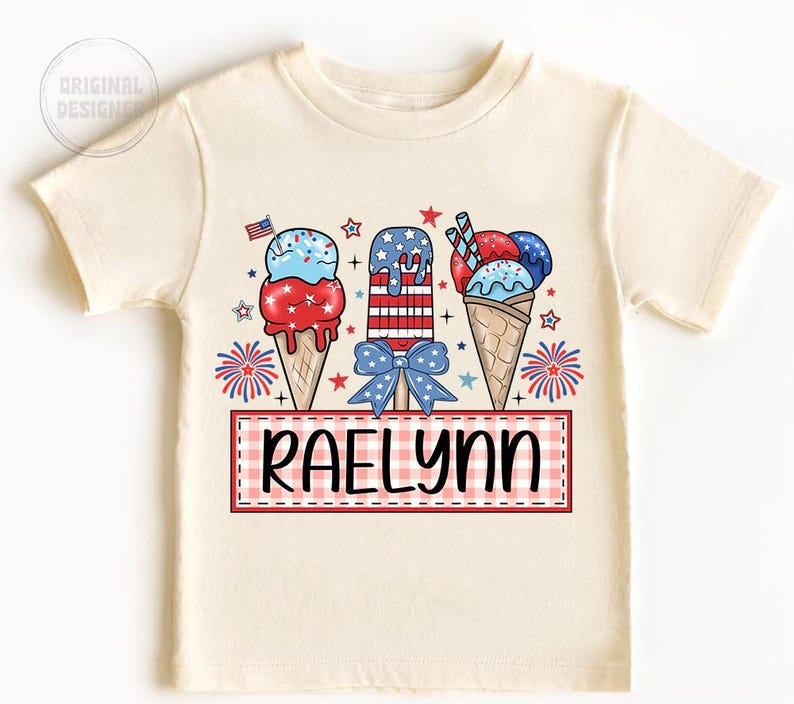 May include: A white t-shirt with a red, white, and blue ice cream cone design. The ice cream cones are decorated with stars and stripes. The text "Raelynn" is printed on a red and white checkered banner.