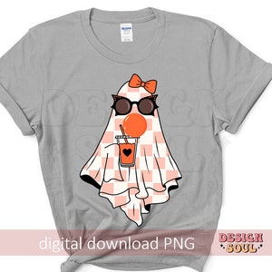 May include: A gray t-shirt with a ghost wearing sunglasses and a bow, holding a glass of orange juice. The ghost is wearing a checkered pattern. The text "digital download PNG" is at the bottom of the shirt.