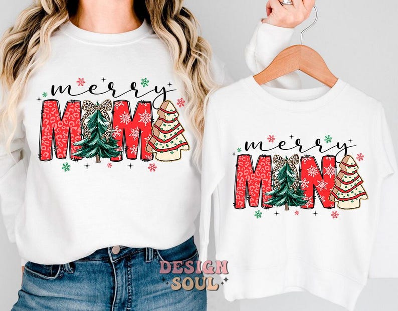 May include: White long-sleeved shirts with a Christmas-themed design. The larger shirt says "merry mama" with a red, green, and white design. The smaller shirt says "merry mina" with a similar design.