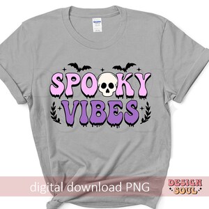 May include: A gray t-shirt with a pink and purple graphic that says "Spooky Vibes" with a skull and bats. The graphic has a dripping effect.