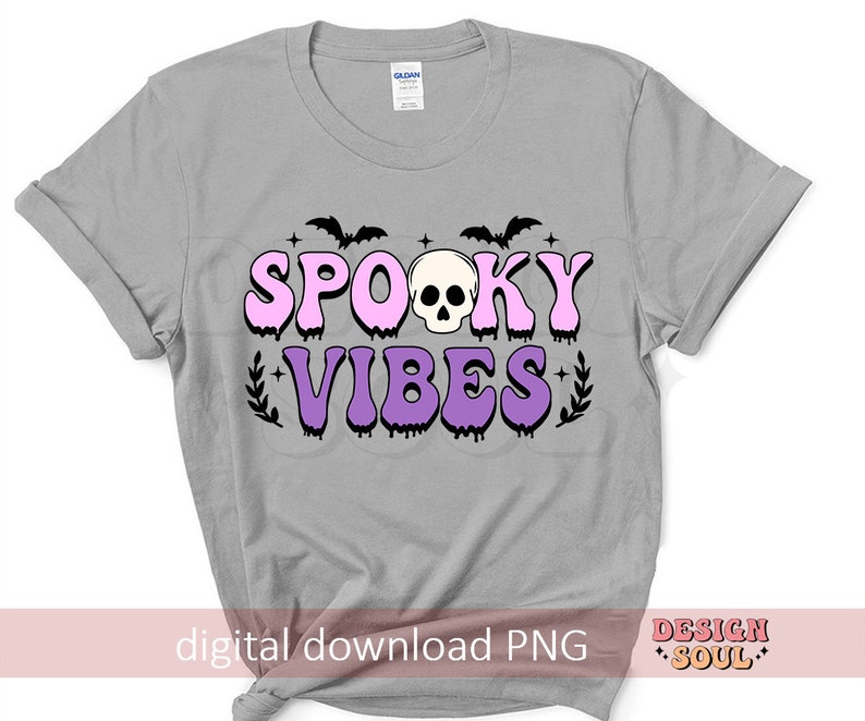 May include: A gray t-shirt with a pink and purple graphic that says "Spooky Vibes" with a skull and bats. The graphic has a dripping effect.
