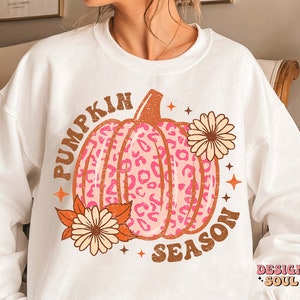 May include: White sweatshirt with a pink and brown leopard print pumpkin graphic and the text "Pumpkin Season".