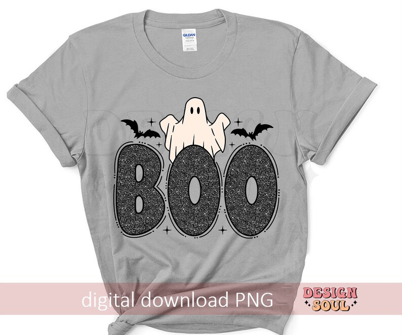 May include: A gray t-shirt with a black and white graphic of a ghost with bats and the word "BOO" in glitter letters.