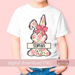May include: A white t-shirt with a pink floral bunny design and the name "Sophia" printed on a banner. The bunny has a pink bow.